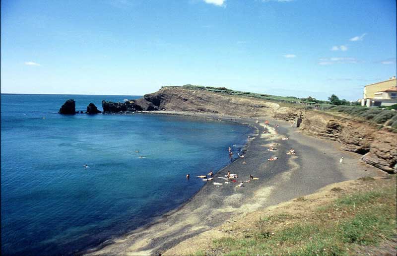 Photo 28 - Plage de la Conque (seule plage de sable noir en France). Le rocher des Deux-Frères a protégé les tufs de l’érosion marine, ce qui n’est pas le cas de la partie centrale de la plage car le filon de basalte est inexistant à ce niveau (Alain Guillon).